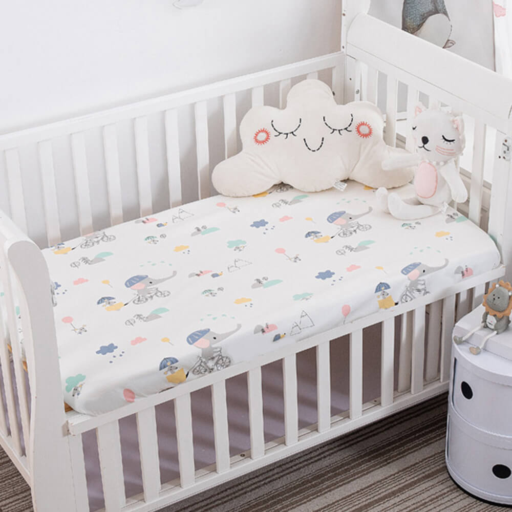 Babelio crib mattress with animal print in a nursery, featuring plush toys in a white crib