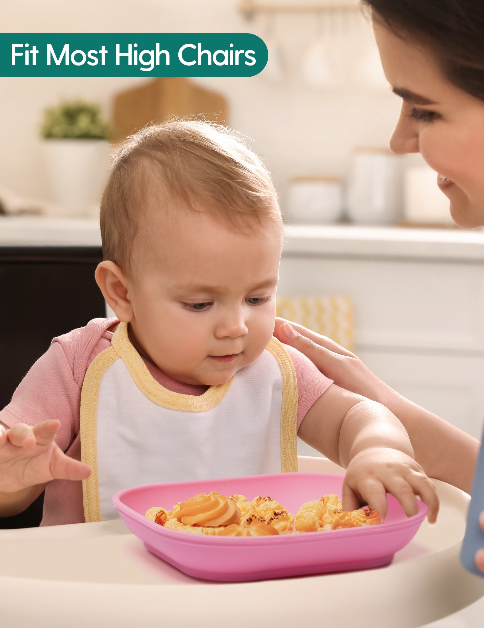 Babelio baby eating snacks in a kitchen high chair with pink silicone plate, modern setting