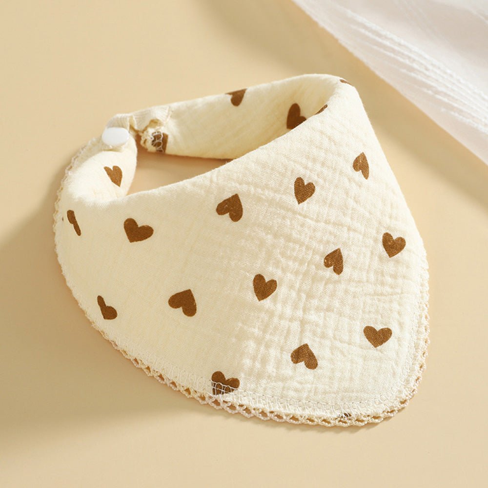 Babelio cotton muslin baby bib with brown heart pattern on a neutral background